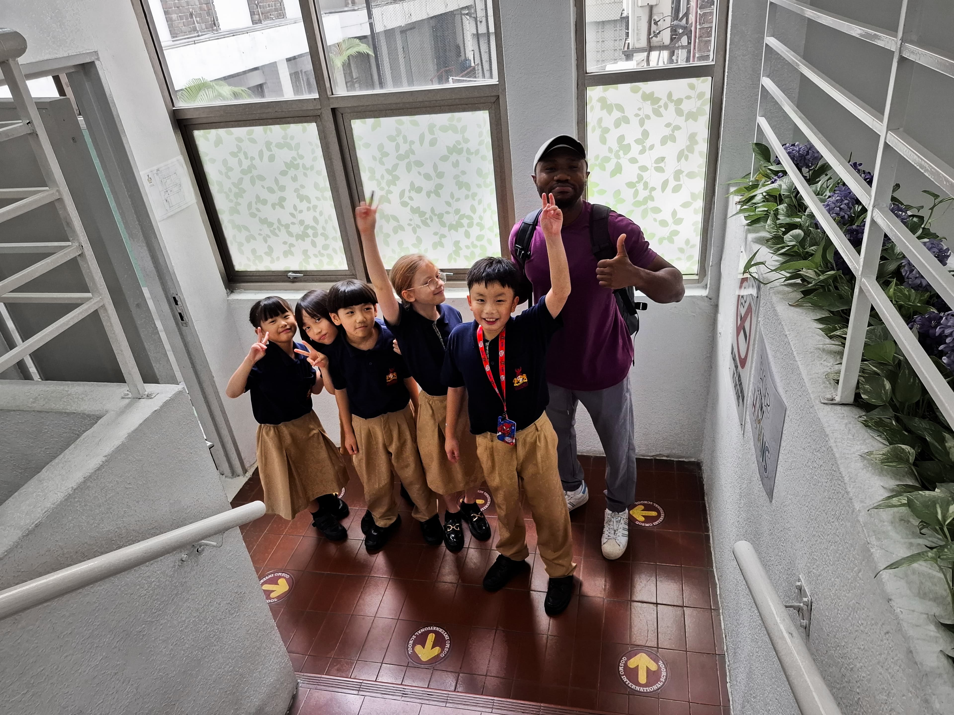Students and a teacher gathered together in a school stairwell.