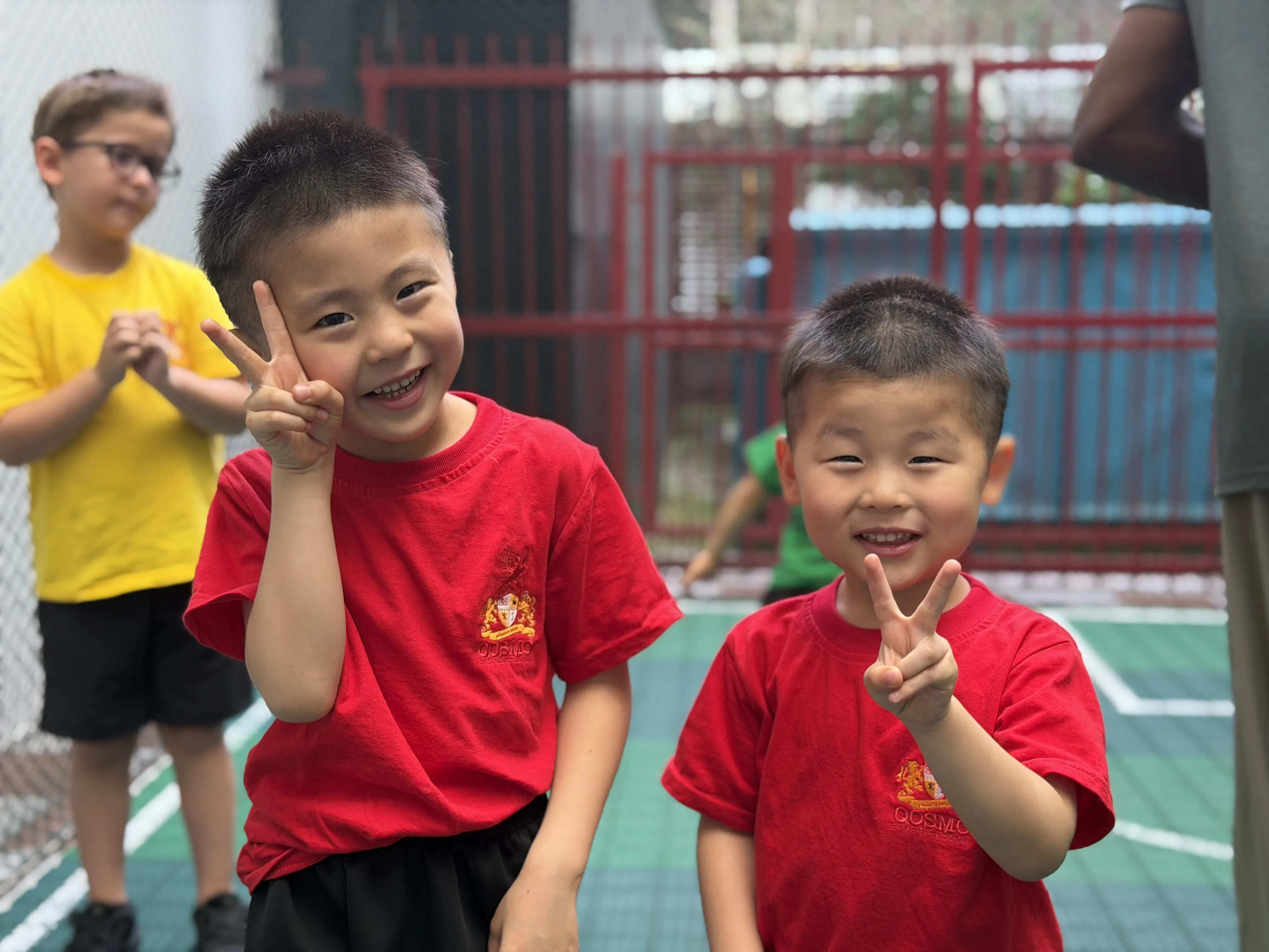 Two young Qosmo students smiling during an outdoor activity.